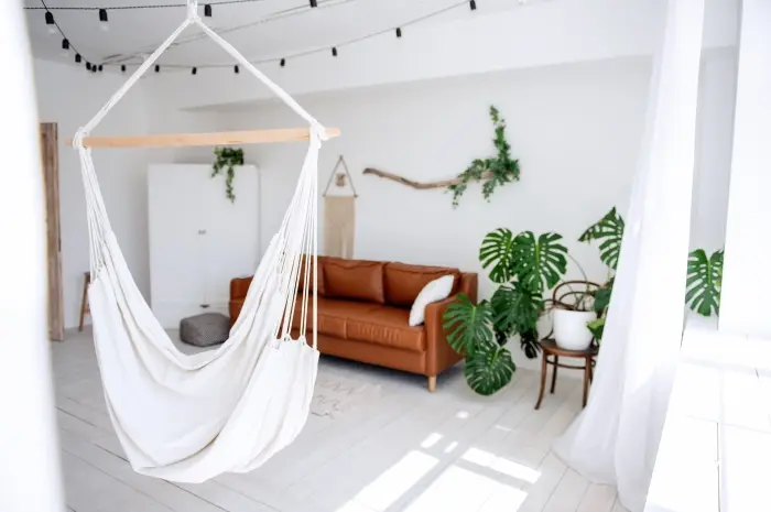 Sofa Cokelat dan Hammock Putih dengan Tanaman Merambat, Seperti di Hutan Tropis